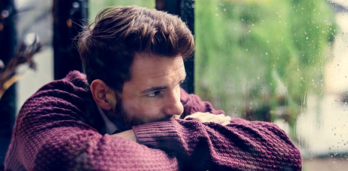 thoughtful-man-looking-out-the-window-PUNZ5HG